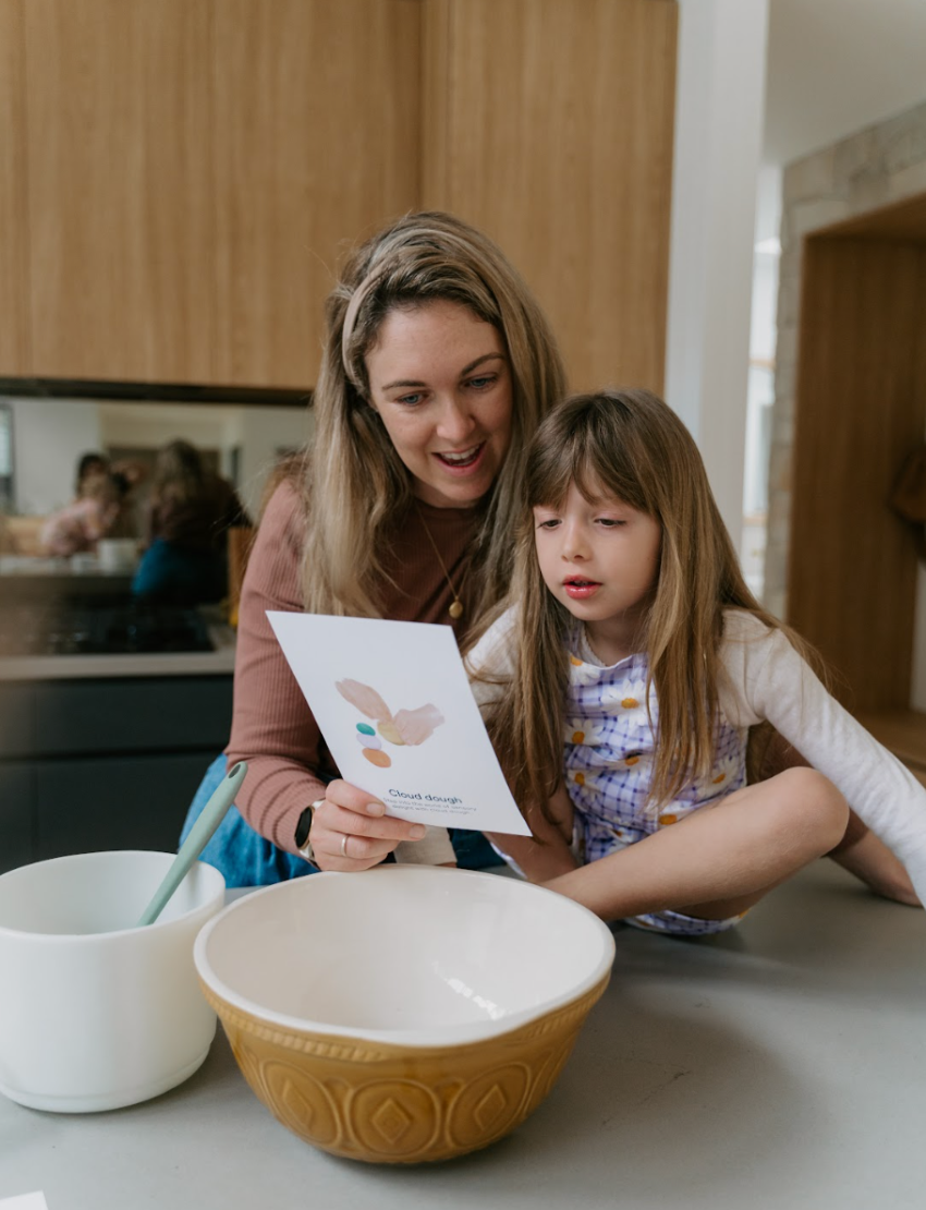 Mother and daughter engage with The Play Way Regulation Card Set Bundle, utilizing a therapist-designed sensory play card for emotional regulation. This kit fosters self-awareness.