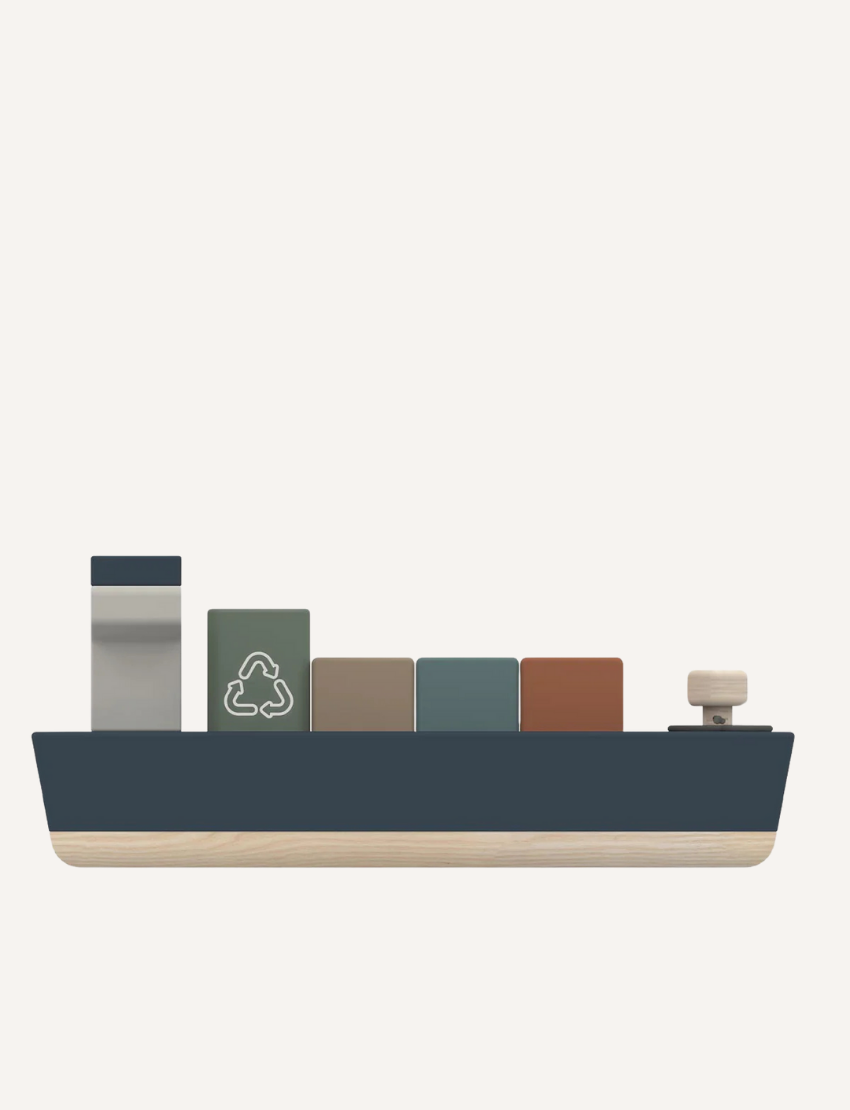 Side view of a wooden toy cargo ship with blocks and recycling symbol.