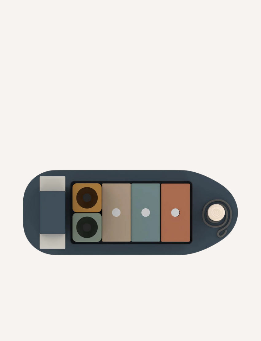 Top view of a wooden toy cargo ship with colorful blocks, including recycling symbol.