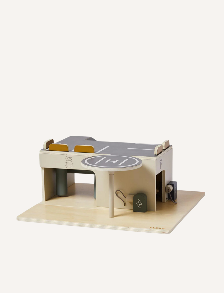 Wooden toy parking garage with helipad and charging station on a wooden base.