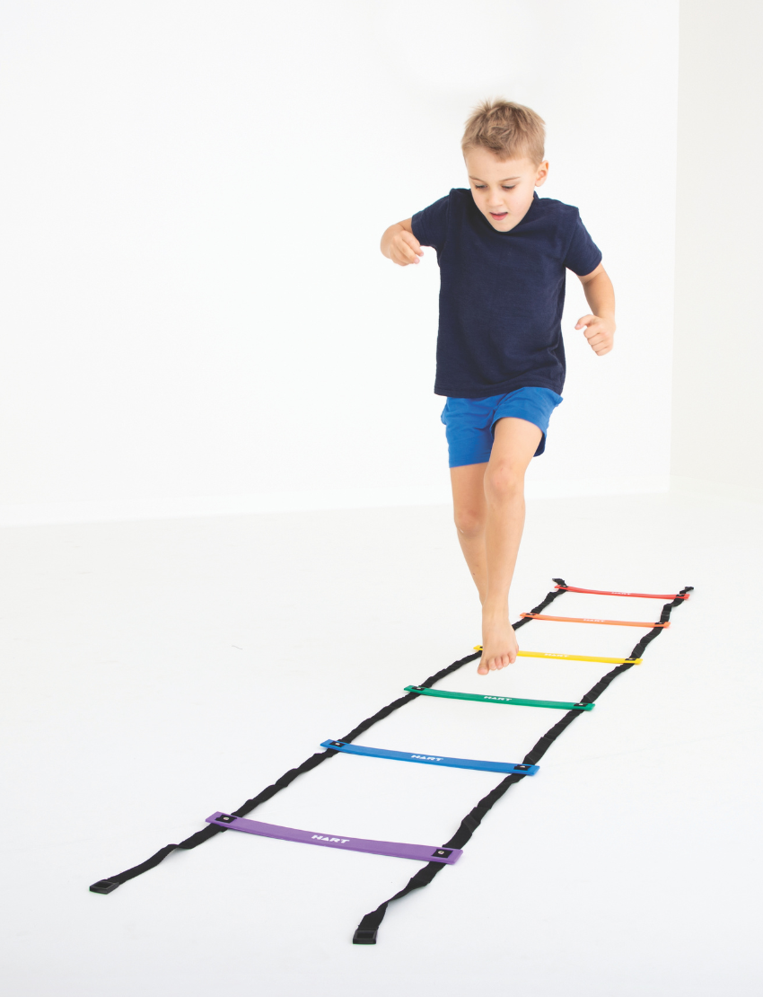 Young boy training with a rainbow agility ladder, enhancing speed and coordination with colorful steps.