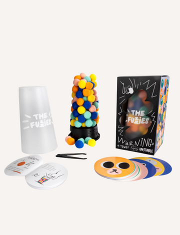 The Fuzzies game set including dispenser, pom poms, cards, and tweezers.