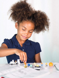 Young girl excitedly playing with space-themed toys, including astronauts and planets, learning about space.