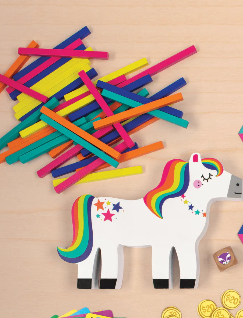 Pony Pile-Up Balancing Game pieces and unicorn figure on a wooden surface.