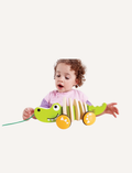 Toddler playing with a Hape Walk-A-Long Crocodile toy, designed for early development and motor skills.