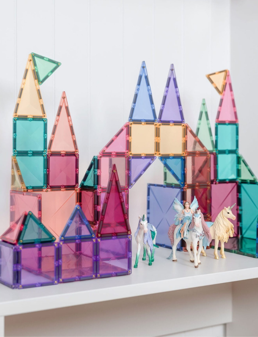 Fantasy castle built with Connetix pastel magnetic tiles, featuring fairy figures and unicorns.