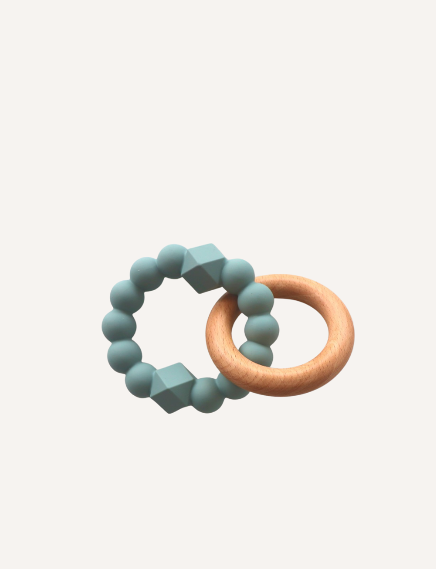 Sage Green Silicone Moon Teether with wooden ring, sensory beads and geometric shapes.