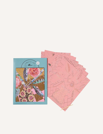 Scratch art kit with light blue box displaying a colorful floral design, alongside pink and gold patterned scratch sheets and wooden stylus.