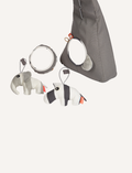 Close-up of grey activity gym attachments: plush elephant, striped zebra, and patterned mirror
