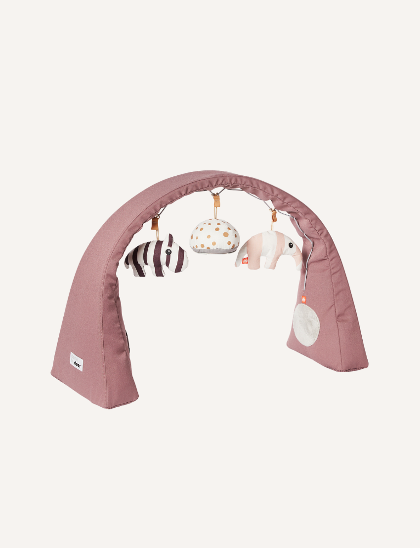 Powder pink activity gym with hanging plush zebra, patterned ball, and striped elephant toys