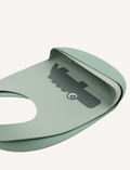 Close-up of a light green silicone baby bib with a dark grey crocodile design and crumb catcher.