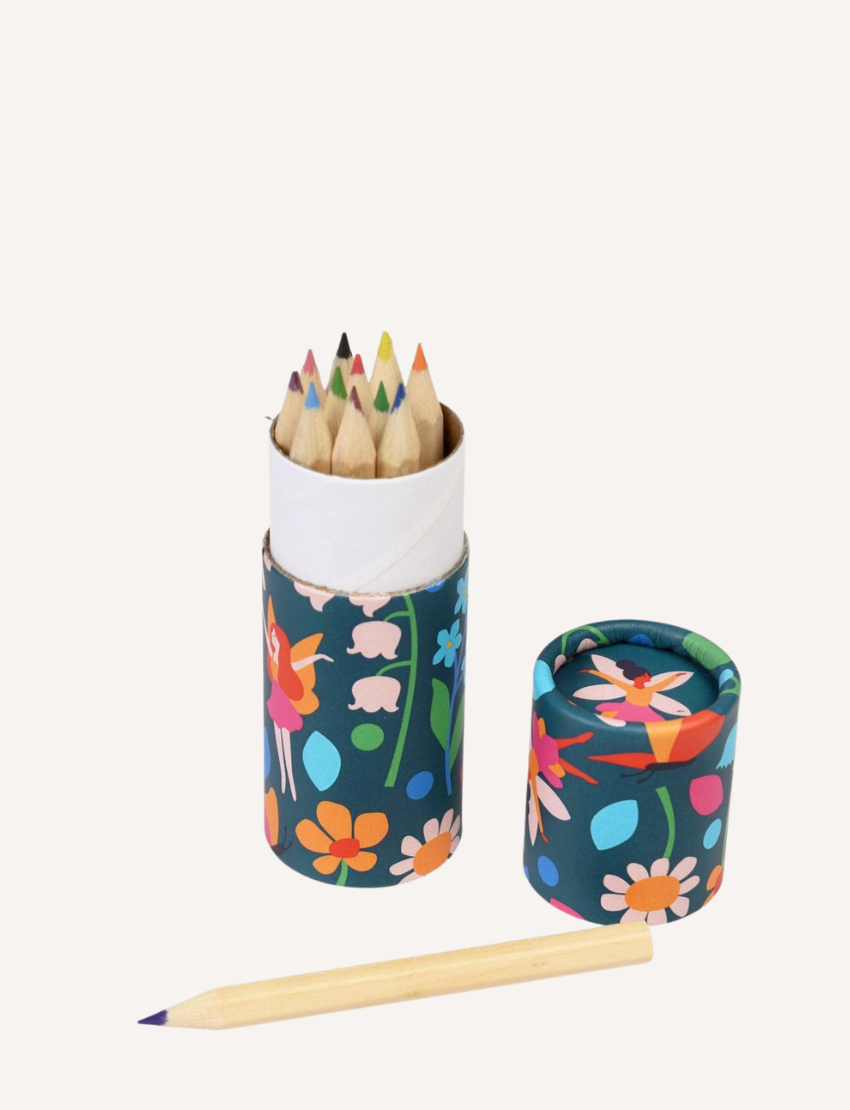 A tube of colored pencils with a fairy-themed design, with one pencil laid out.