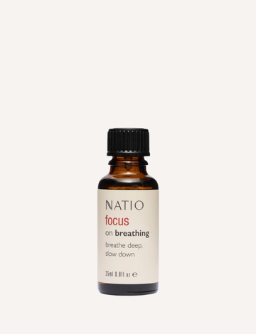 A small brown bottle from Natio, labeled "Focus on Essential Oil Blend," features a black cap and the phrase "breathe deep, slow down" for relaxation. Ideal for diffusers, it contains 25 ml (0.81 fl oz) of calming essential oils.