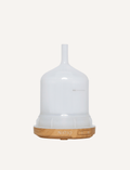 Empty white ultrasonic diffuser with a wood base and controls.