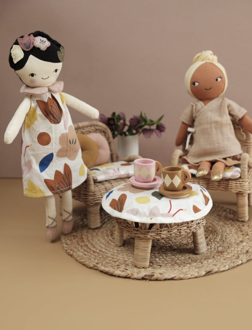 Plush dolls 'Simran' and 'Mei Mei' with a tea set on a rattan table