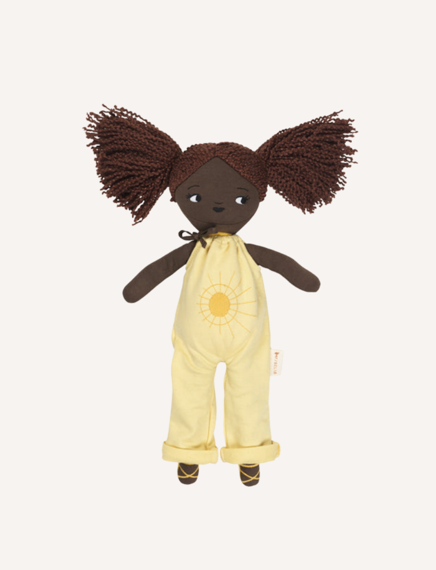 Plush doll 'Sol' with dark skin, textured pigtails, and yellow sun jumpsuit