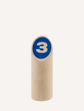 Close-up of a wooden pin with a blue circle and the number '3' for a toss game.