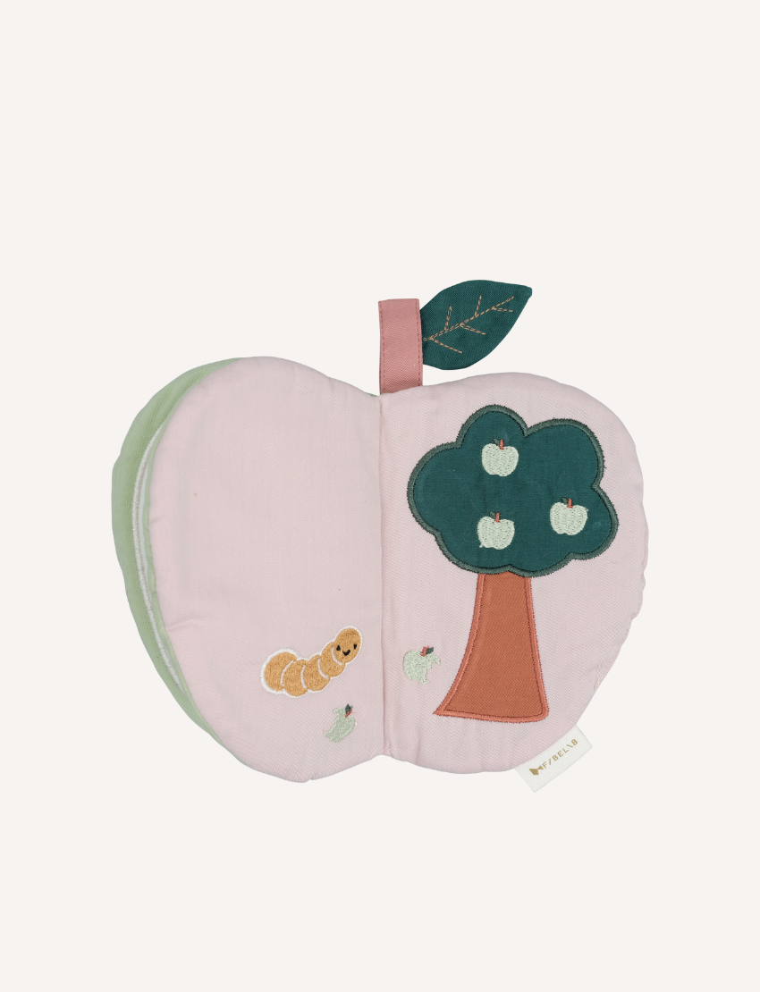 Closed green fabric apple book with a white flower and bee applique on a light background.