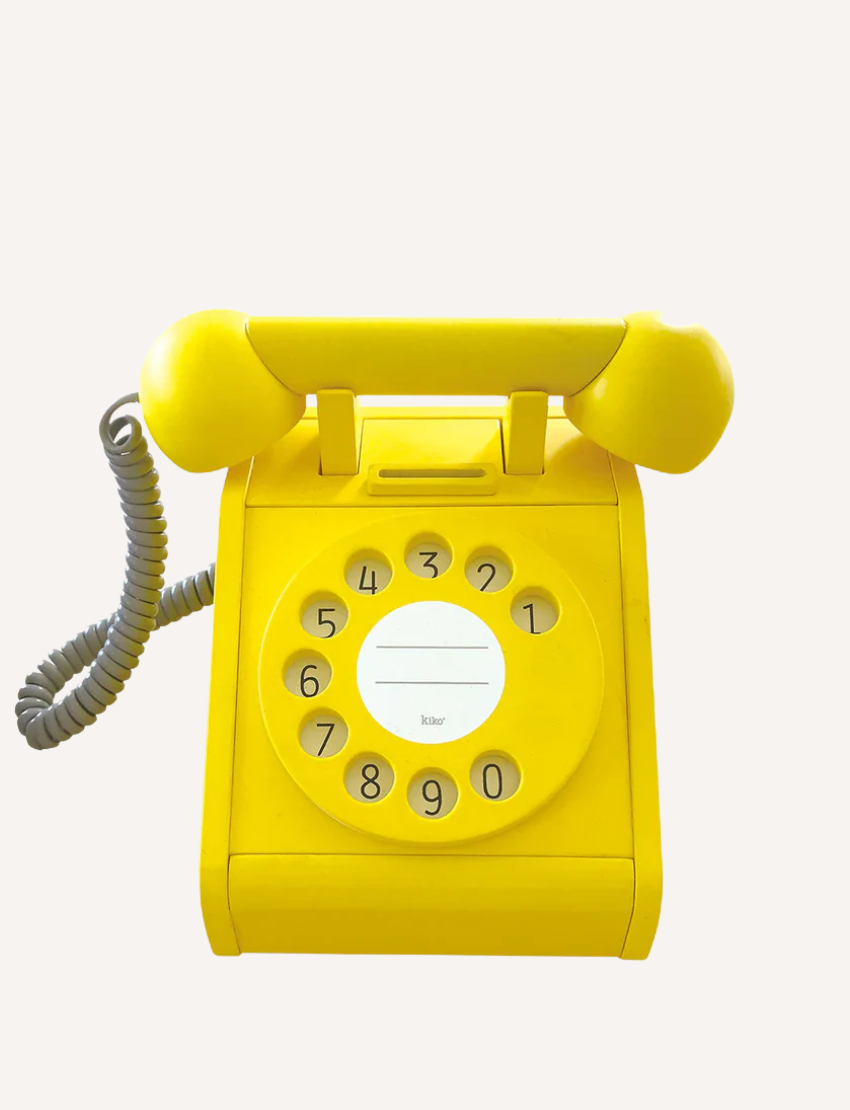 Bright yellow retro-style toy rotary telephone with a numerical dial, coiled cord, and a receiver. Perfect for children's imaginative play.