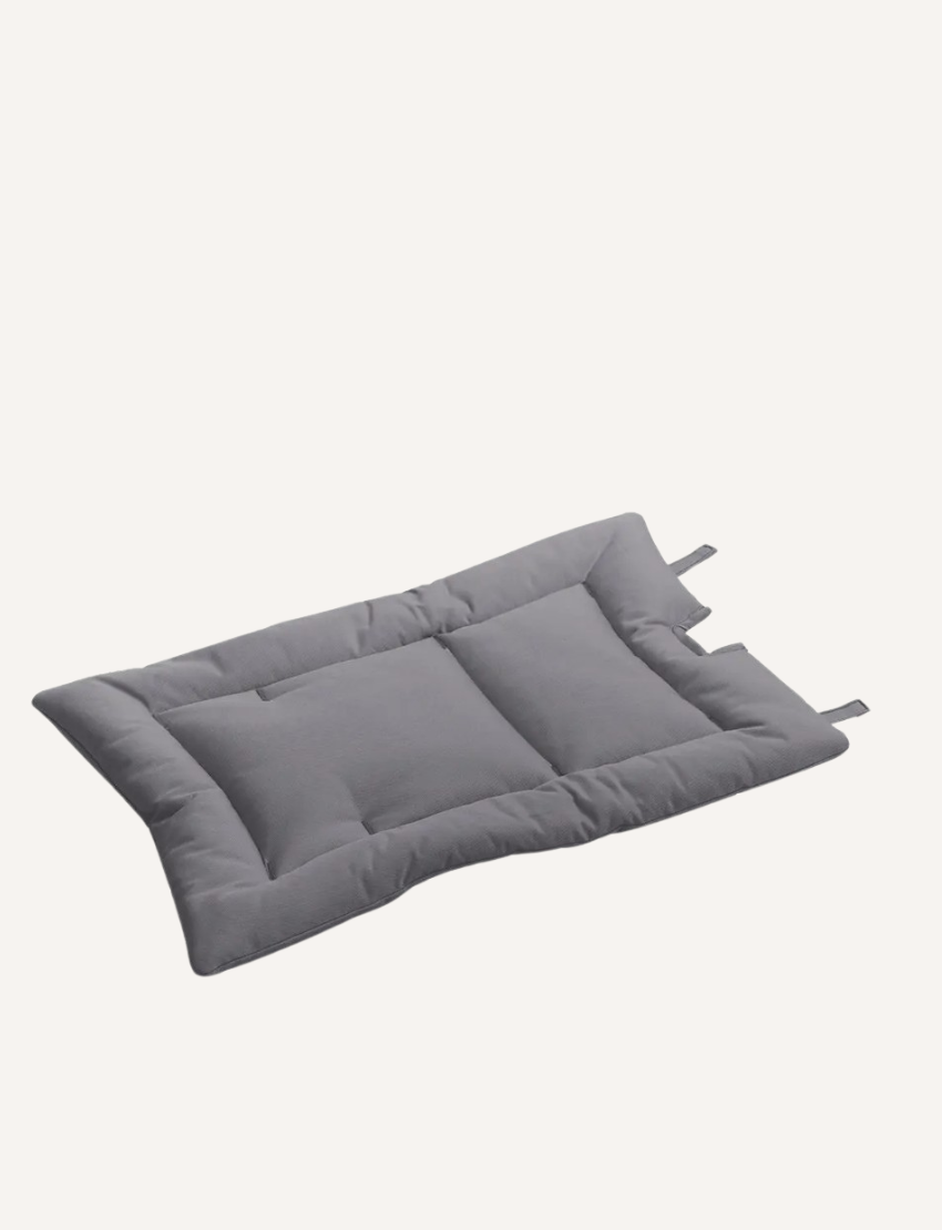 Grey quilted cushion for a high chair, with attachment straps.