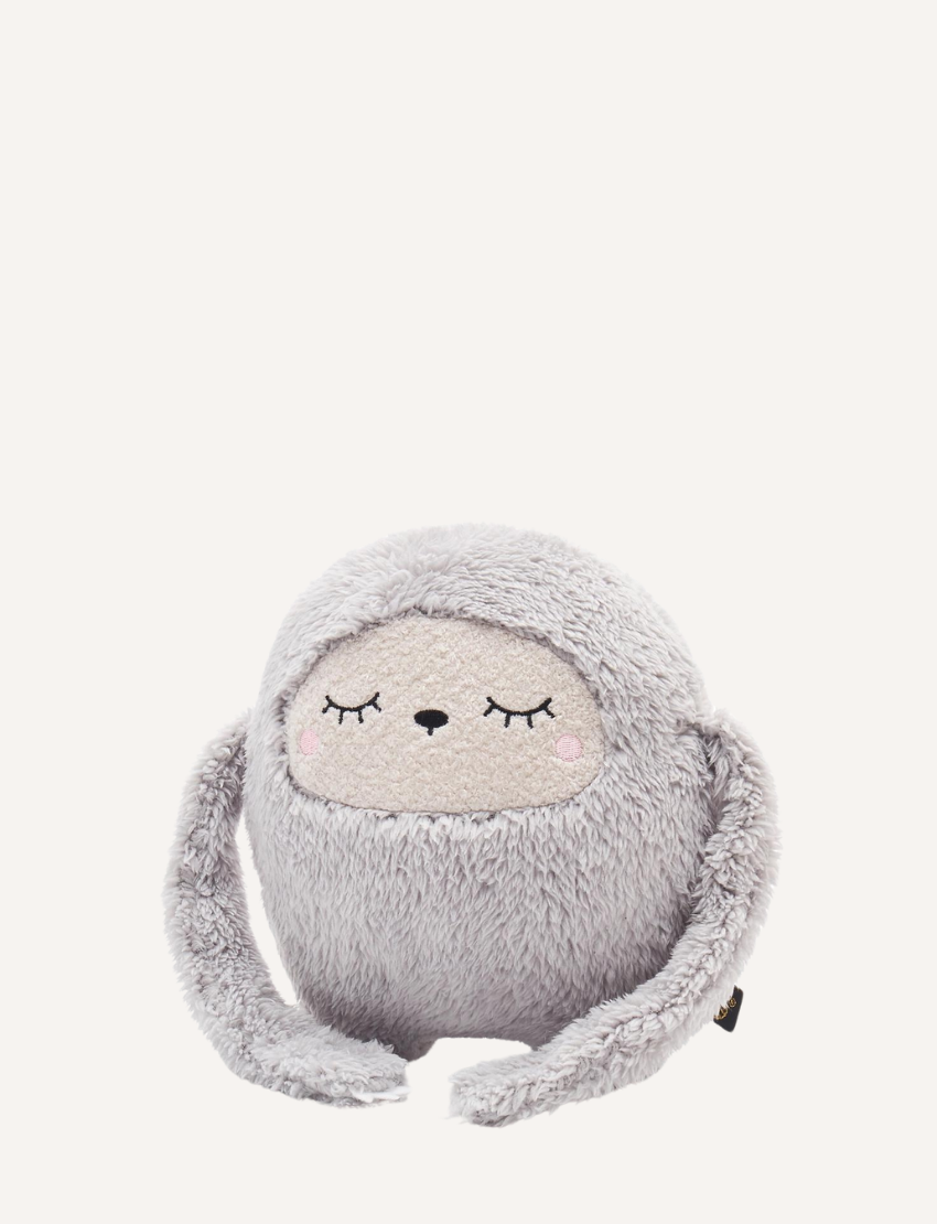Fluffy grey plush toy with sleepy eyes and ears tied on top, on white background.