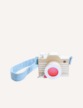 A wooden toy camera with white stripes and a pink lens, featuring a light blue denim strap.