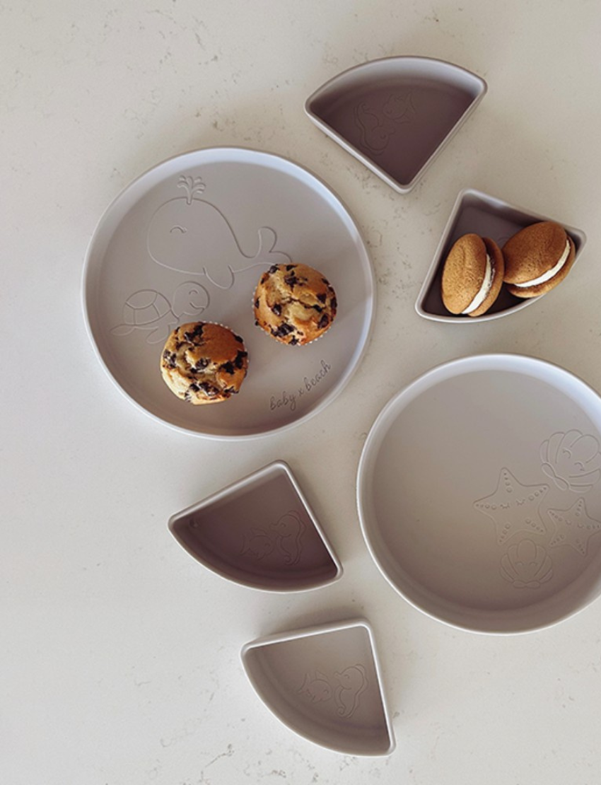 Grey Silicone Divided Plates with muffins and biscuits, featuring whale and starfish designs.