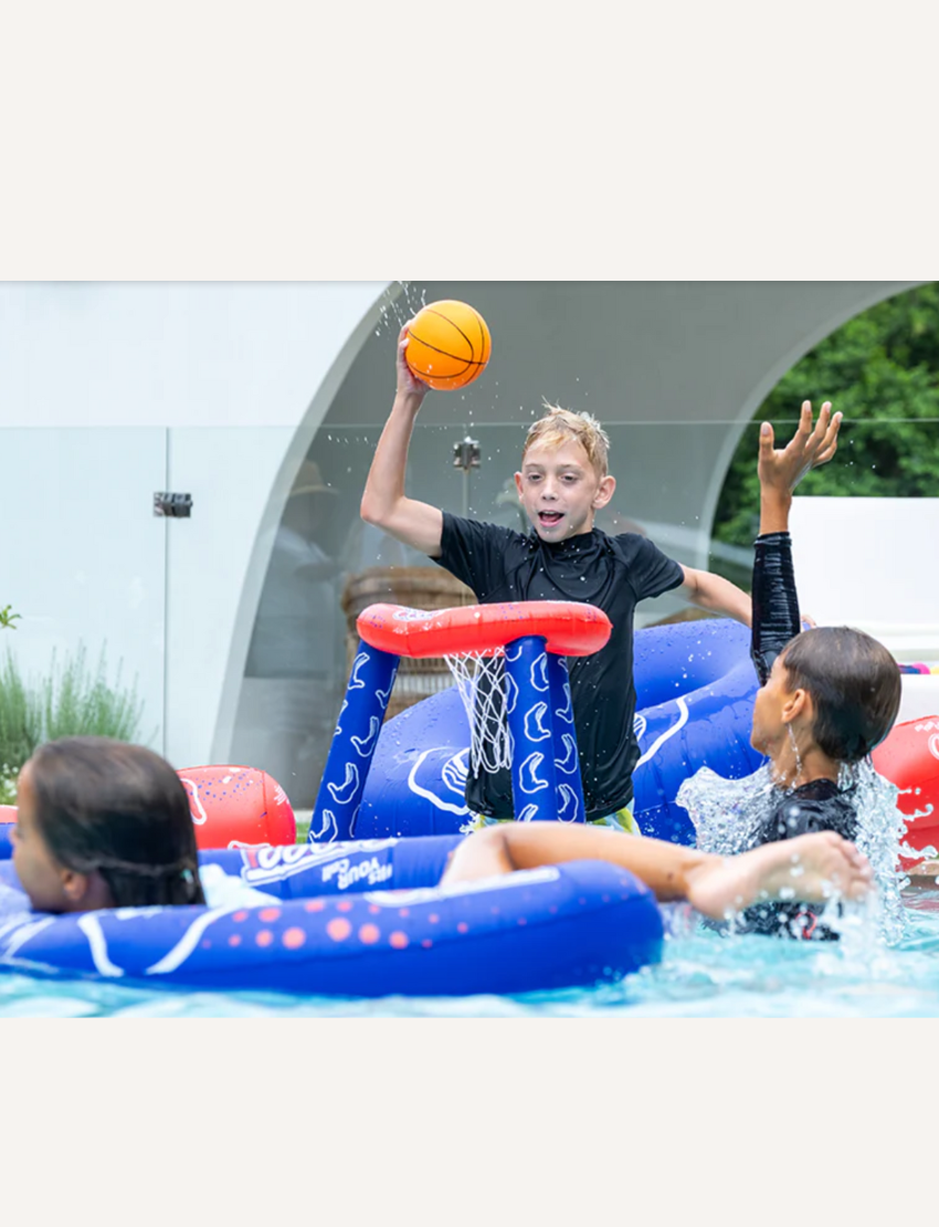 Children playing pool basketball with an inflatable hoop, one boy shooting a ball.