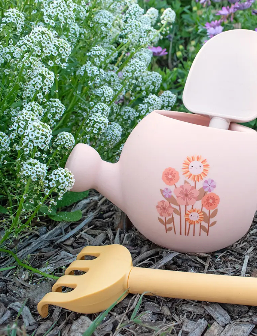 Blue watering can with a tractor design, holding a green rake and yellow spade.