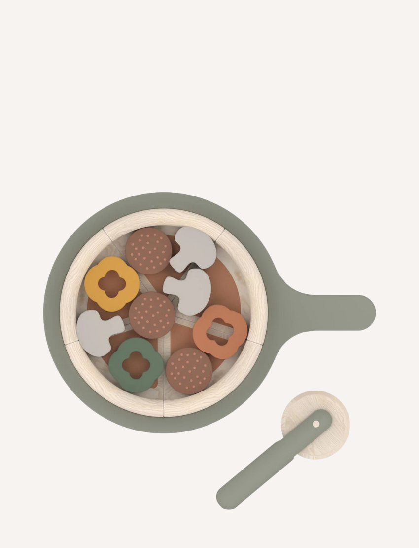 Top view of a wooden pizza set with toppings like mushrooms, peppers, and meatballs in a pan.
