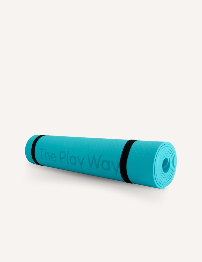 The Play Way Large Yoga Mat in tranquil teal, rolled up with black carrying straps, offering a cushioned, non-slip surface.