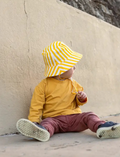 Adorable toddler wearing a bright yellow and white striped bucket hat, providing stylish sun protection for outdoor play.