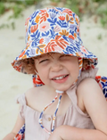 Smiling toddler wearing a vibrant floral bucket hat with chin strap, ideal for sun protection during outdoor play at the beach or park.