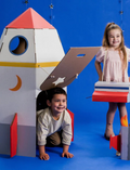 Two children playing with a large cardboard rocket ship. Fun, imaginative space adventure play and DIY kids' craft.