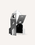 Cardboard rocket model, gray & white, with open door and moon/star cutouts.
