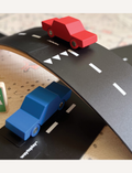 Close-up of Way to Play wooden cars on a flexible road track. High-quality toy cars for imaginative play.