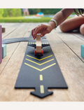 Close-up of a child's hand playing with a wooden airplane on a Way to Play airport runway. Airport play mat for kids.