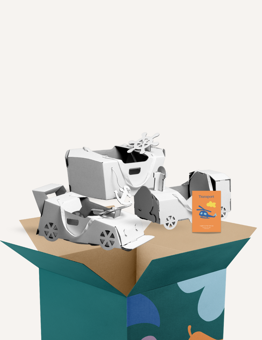 Cardboard 3D transport models including cars and a helicopter, with a booklet, partially in a box.