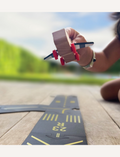 Close-up of a child's hand holding a wooden airplane on a Way to Play airport runway. Airport play for kids.