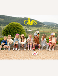 Group of children with Chaps Mail plush toys sitting on a wall, showcasing fun and playful fashion.