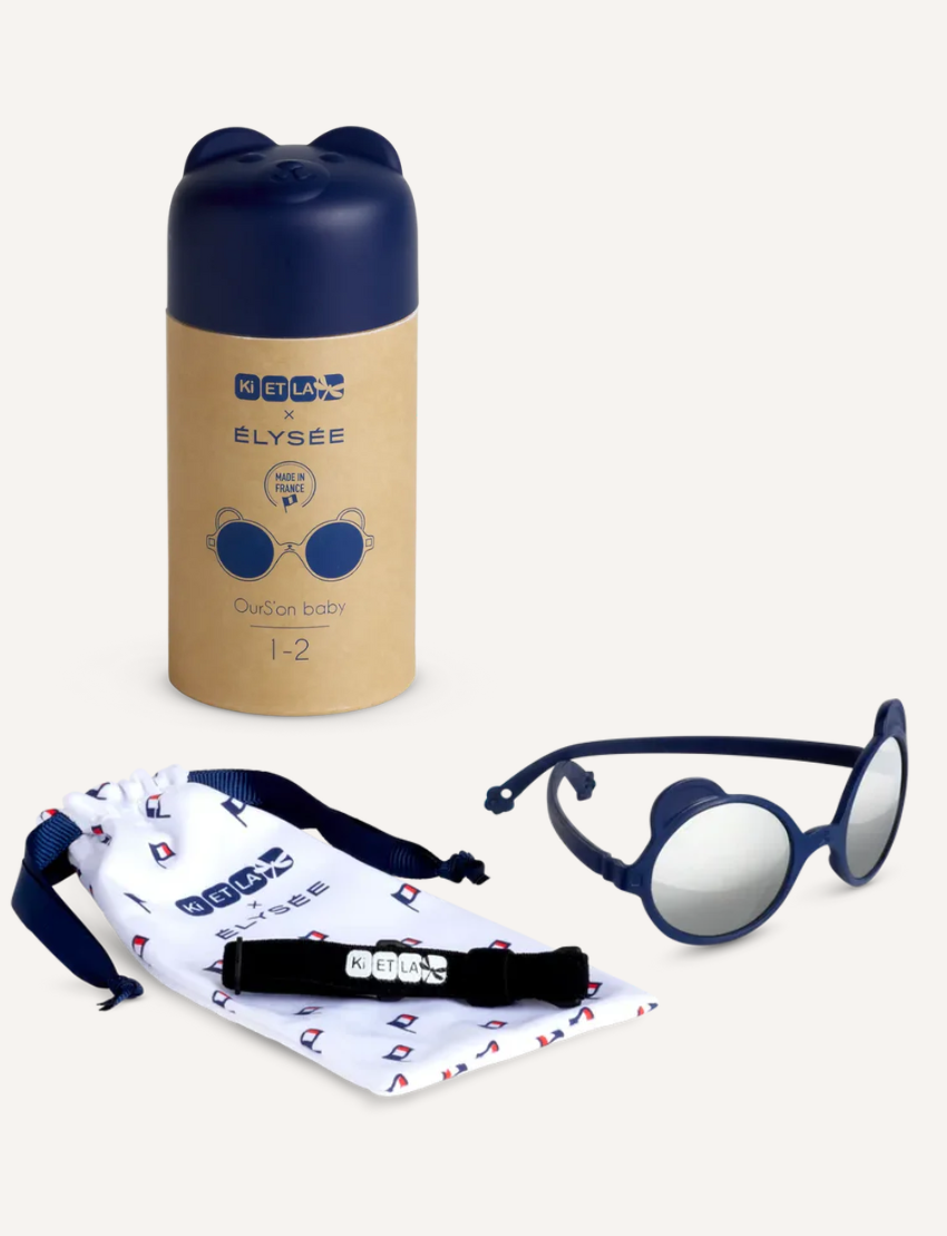 Four cute, animal-shaped sand molds on a sandy beach: pink pig, grey bear, grey bear, blue pig.