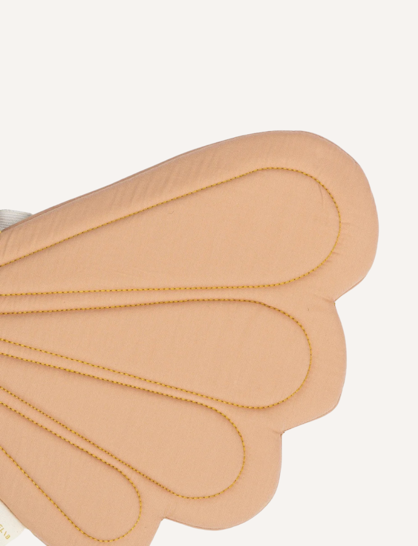 Close-up of dusty rose fairy wings with intricate gold stitching, showing texture.
