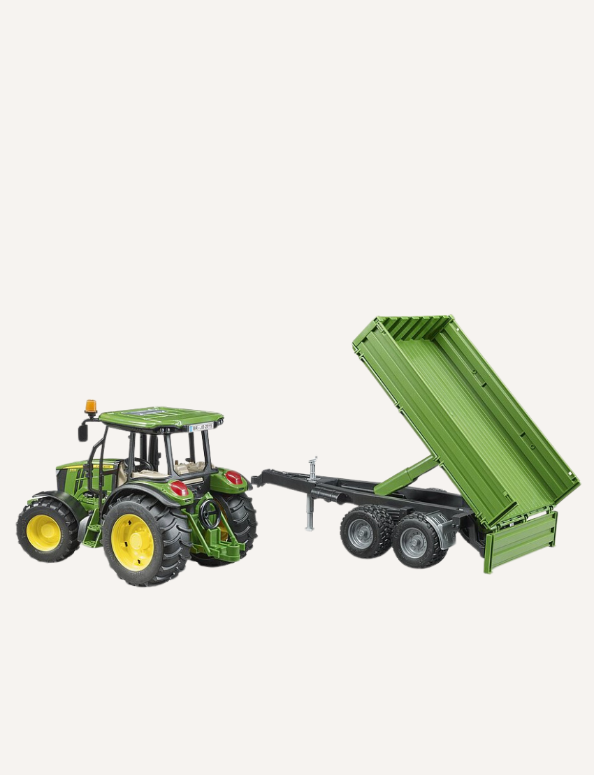 Green John Deere tractor with a trailer, shown from the side.