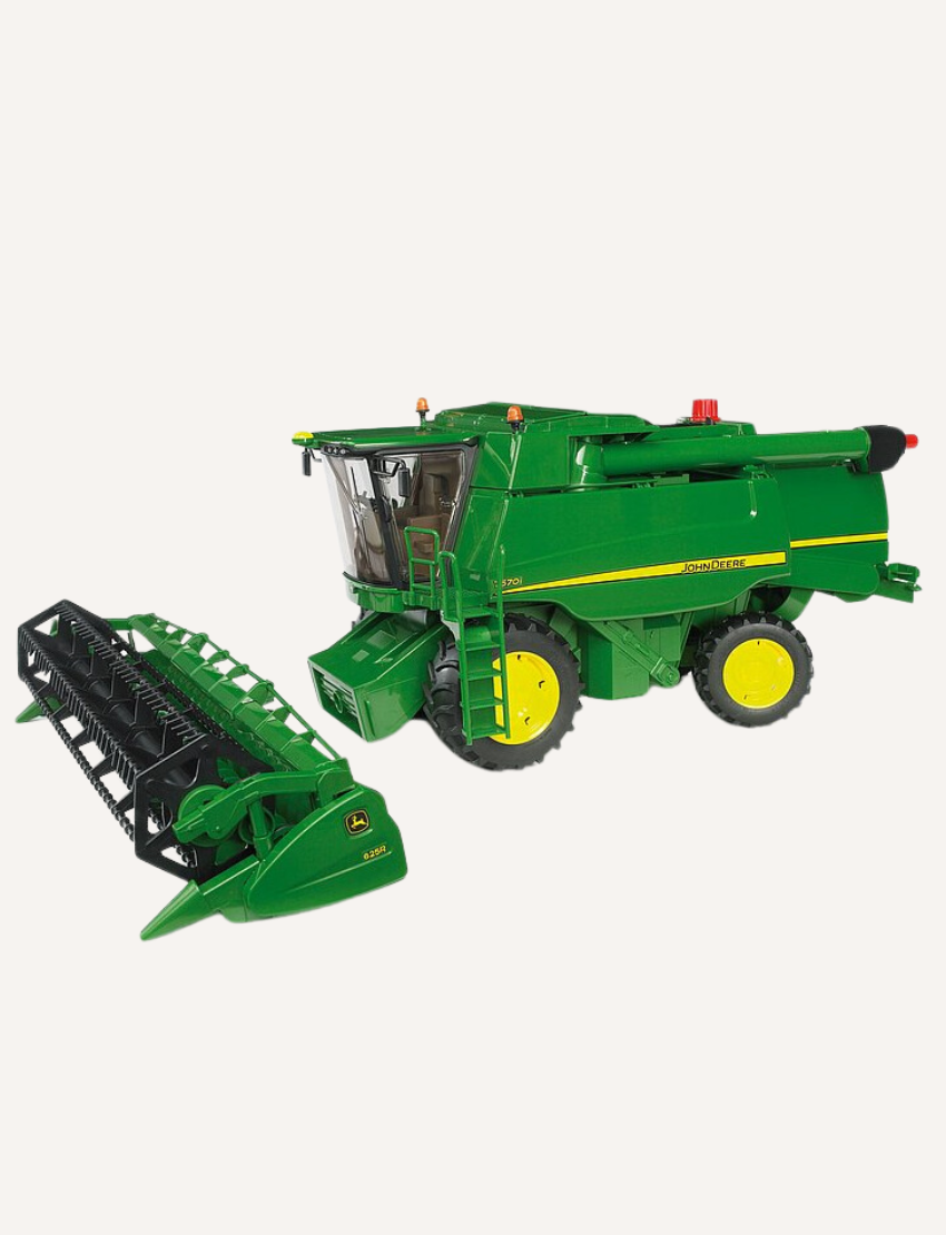 Green John Deere combine harvester with its header detached, placed in front.