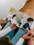 Hands holding open The Play Way's 'Buzzing Bees' book, a therapist-designed tool for emotional regulation.