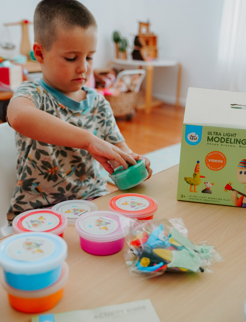 The Getting Ready to Write Program by Therapy At Home includes booklets, clay, a yellow tray, and educational tools for kids—ideal for developing handwriting skills—with items neatly arranged in the colorful box.