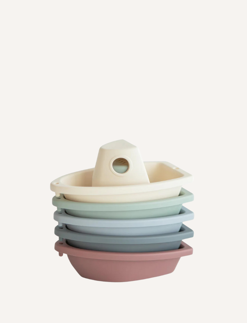 Stack of five pastel-colored nesting boat bath toys for kids, with a removable top piece, perfect for water play.