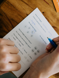 A close-up of hands completing a worksheet from The Play Way's Reflection Kit, aiding children in emotional processing and self-awareness.
