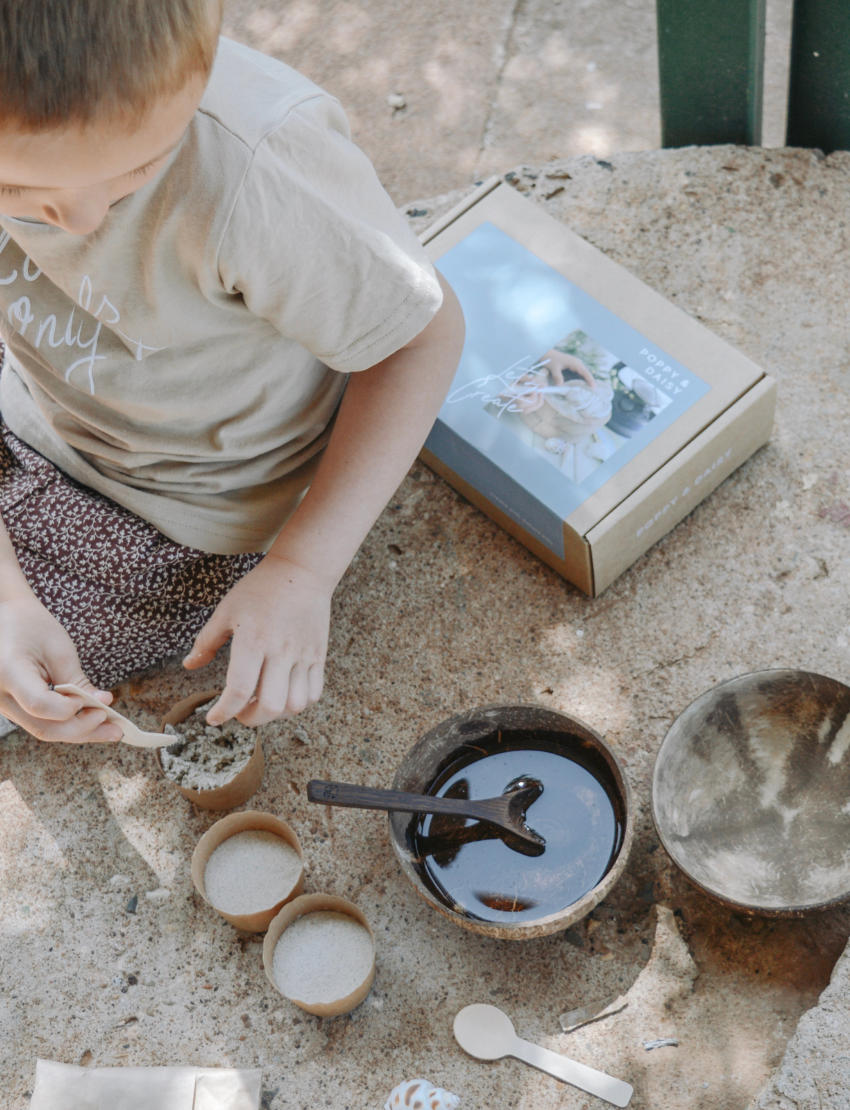 Child engaged in a 'Fun Fossils' DIY kit activity with sand and plaster.