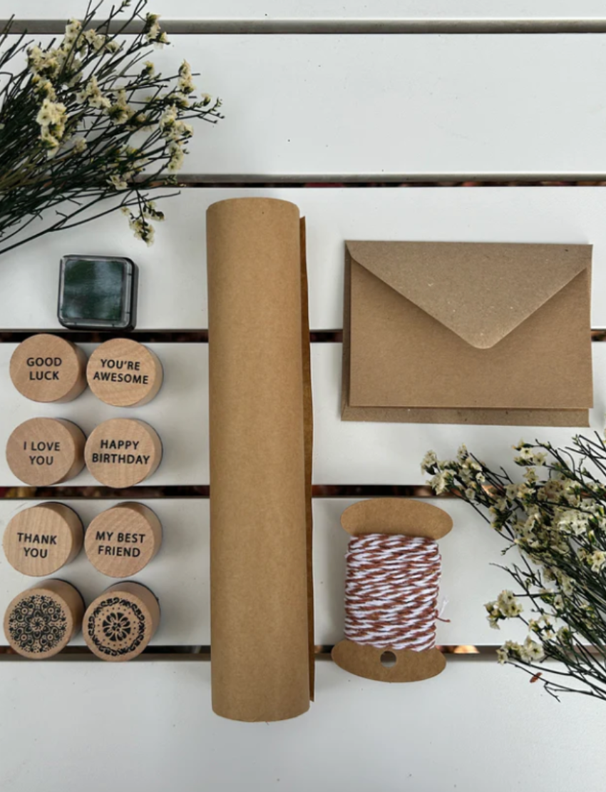 Poppy & Daisy DIY Gifting Set: Eco-conscious kit with stamps, twine, envelope, paper roll for creative gifting.